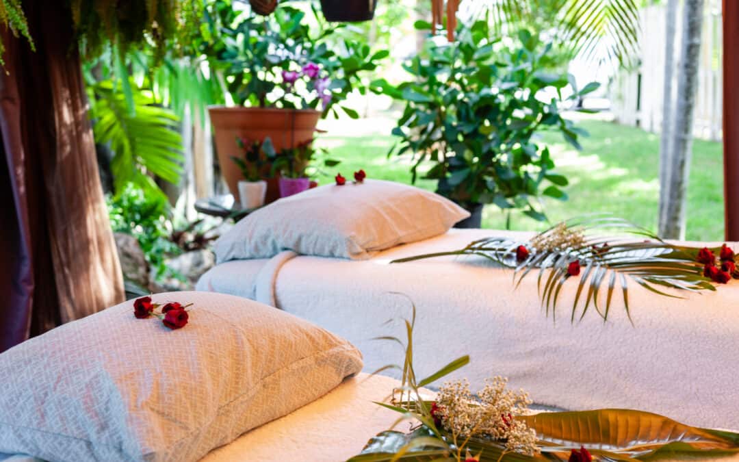 Two massage beds in an outdoor room adorned with plants and flowers, offering the perfect setting for an invigorating outdoor massage in Fort Lauderdale.