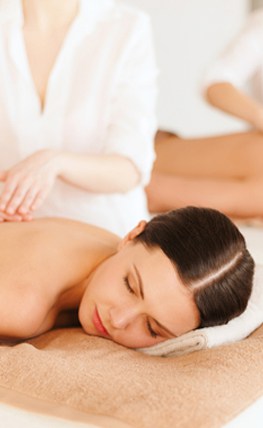 A woman attending a back massage workshop in a spa.