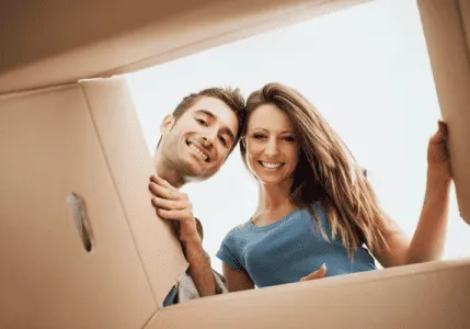 A man and woman peering out of a cardboard box while hunting for Fort Lauderdale's Best Facial!